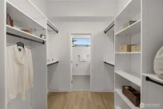 Spacious walk-in closet with custom storage keeps everything organized and within reach.