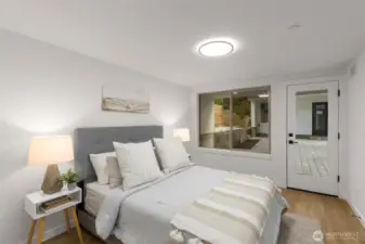 Secondary bedroom with oversized windows and easy outdoor access offers comfort and flexibility for guests or family.