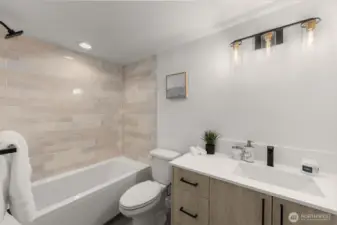 Sleek full bath with modern tile and a deep tub for ultimate relaxation.