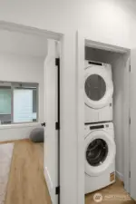 Laundry room with modern appliances and built-in storage simplifies everyday living.