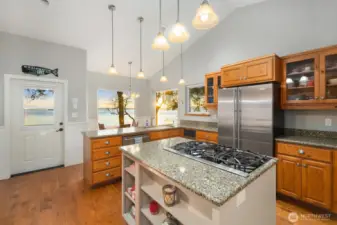 Bright kitchen with granite countertops, gas cooktop island, stainless appliances, and skylights—ideal for entertaining in this Friday Harbor waterfront home.