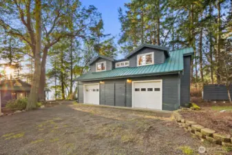 Detached garage/shop with ample parking and forested surroundings, providing storage, workspace, and classic Pacific Northwest privacy.