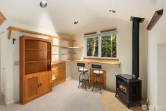 Cozy seating area featuring freestanding stove and built-in shelving—an inviting retreat filled with warmth and character.