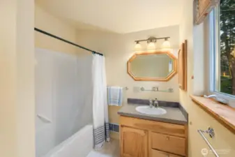 Inviting full bath with classic finishes providing comfort and functionality within the private studio apartment.