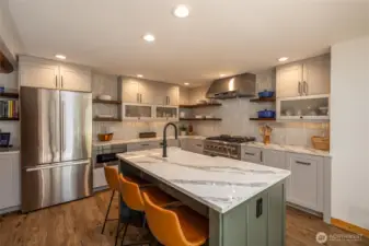 The gourmet kitchen features high-end Bosch appliances, gas cooking, a built-in microwave drawer, breakfast nook, and eating bar—perfect for hosting friends and family.
