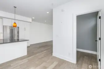 Looking from the top of the stairway on the main level with the powder room to the right and the kitchen to the left.