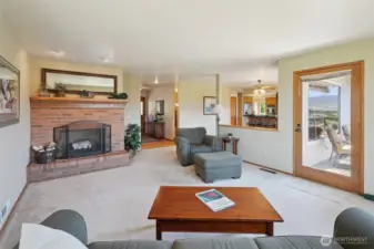 main level living area with fireplace and door to wrap around deck