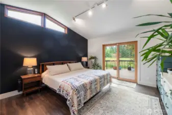 Located on the main floor, this primary bedroom is sure to please with plenty of natural light, vaulted ceilings, and private access to the back deck.