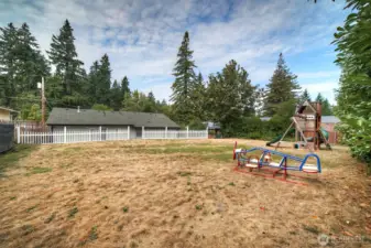 Large partially fenced backyard.