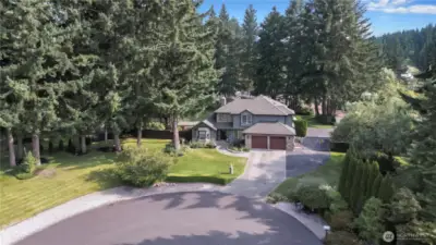 This beautifully landscaped property boasts a tranquil, woodsy setting, creating a peaceful and serene environment perfect for relaxation and enjoyment, with mature trees and well-maintained grounds.