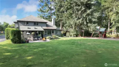 Rear of home patio nicely landscaped back yard. The backyard offers a comfortable and inviting space for relaxation and outdoor activities, featuring well-maintained landscaping and a patio area perfect for entertaining or enjoying peaceful moments.
