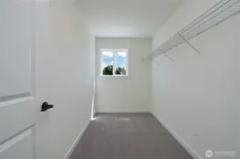 Upstairs Primary Walk-in Closet - Features and colors may differ.