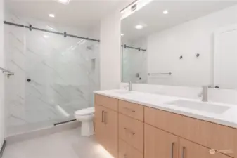 Main floor primary bathroom with walk in shower and heated floors