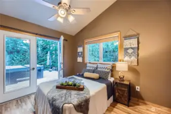 This spacious bedroom features private deck access through French doors, providing a seamless indoor-outdoor flow to relax in the hot tub after a long day.