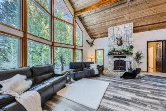 A dramatic wall of floor-to-ceiling windows floods this living room with light, seamlessly blending indoor and outdoor beauty for an unforgettable living experience.