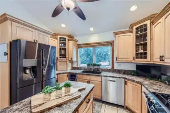 This beautifully designed kitchen boasts fingerprint-resistant black stainless appliances, a WiFi-enabled refrigerator, and double ovens with a gas range, making cooking both effortless and stylish.