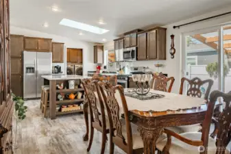 Dining area open to the kitchen and living room. To the right is a slider out to the backyard and covered deck.