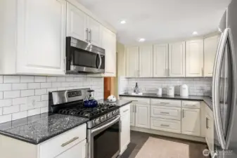 Updated kitchen with granite counters, subway tile backsplash and SS appliances.