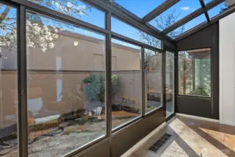 Sunroom with door to the private patio and garden space