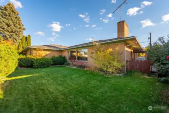 This view includes the north side of the home with a glimpse of the side yard and heat pump.