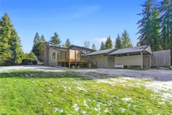 Back outside, this photo shows the yard,  2-car garage and carport