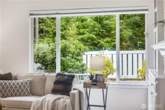 The greenbelt of mature trees behind the home offer privacy and peaceful views year-round from this main living area.