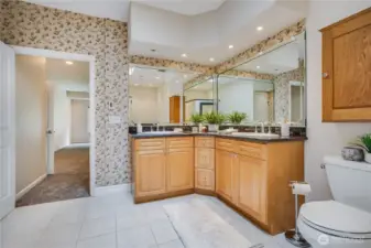The dual-sink vanity offers plenty of countertop space and storage room below. The primary suite bathroom also features a step-in tub and a linen closet.