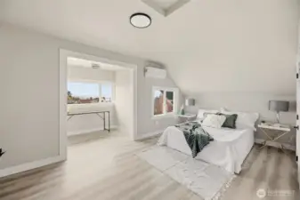 The serene primary bedroom is bathed in natural light from its generous windows, creating a bright and welcoming retreat.