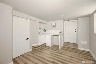 Just past the living room is the kitchen/dining area. You could put a bistro table here and have your own eating area. Door straight ahead is a private entrance. Door to the left is a 3/4 bath.