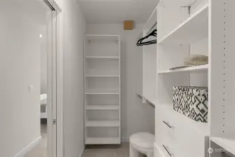 Step into this generous walk-in closet, offering ample storage with custom shelving and drawers to keep your wardrobe organized and easily accessible.