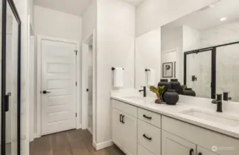 Model home primary en-suite bath with linen storage, walk-in closet, and separate water closet