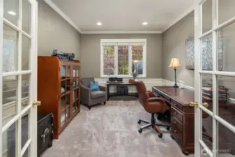 Main floor office with French doors wainscoting and crown molding.