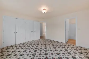 The primary bedroom is on the main level. In addition, the entire house has a total of 3 beds and 2.5 baths.  The primary bath is through the door on the right.  The door straight ahead enters into a hallway, which is just off the living room.