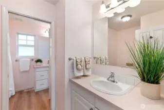 The primary bathroom has two sinks.  One area has a sink and the tub/shower enclosure. A pocket door can be closed to isolate the second sink and water closet guests can access from the living area.