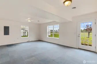 The lower level of the home houses a 2-car garage, this large bonus space with access to the back yard & the laundry room - 1/2 bath. This room is also plumbed for gas which provides the option of adding a 2nd gas fireplace.  Numerous windows bathe the space in natural light. With its own exterior access and downstairs plumbing there may be future MIL options.