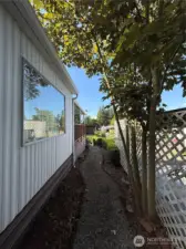 Walkway from backyard to the front of the house and front, covered deck.