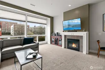 Step into a sunlit living area highlighted by floor to ceiling windows that flood the space with natural light and offer panoramic views.