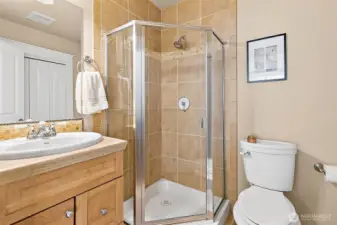 This guest bathroom has floor to ceiling tiled shower, matching vanity and coordinated flooring designed to enhance the overall look. Additionally, there is a large storage closet perfect for those large items like a vacuum.