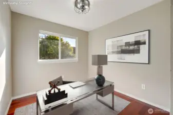 Just down the hall, the generously sized secondary bedroom—currently staged as a home office—adds versatility and function, easily adapting to your lifestyle needs.