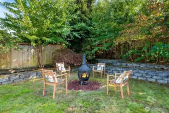 A charming firepit creates the perfect setting for cozy evenings, while a garden area and stands of bamboo add texture, privacy, and character.