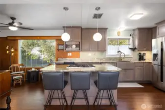 The island has an eating bar & pendant lights.