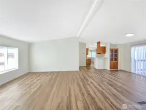 Spacious living room that flows directly into the dining room, making the space feel open and inviting. New flooring and updated lighting.