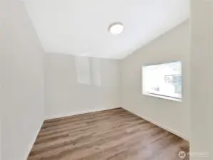 Secondary bedroom featuring vaulted ceilings and updated lighting.