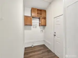 Laundry room with added storage above the washer and dryer and access to the rear porch.
