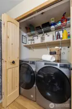 Quaint wood doors hide the handy laundry space with nice shelving. The newer front load washer & dryer are included