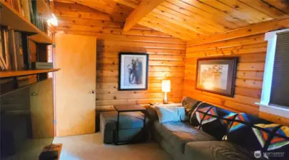 Stunning wood architecture defines this private sitting room, where rich Lindal cedar walls and exposed beams create a warm and inviting retreat. The space seamlessly flows into the primary suite, blending rustic elegance with coastal sophistication.