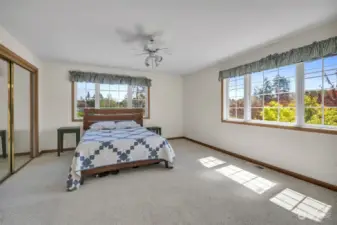 Spacious bright second bedroom in southeast corner with windows on east and south side and full north wall closet.