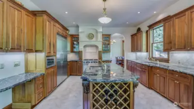 This gourmet kitchen is a chef's dream, combining high-end finishes with a functional design. Rich wood cabinetry offers ample storage, while the stunning granite countertops and backsplash add a luxurious touch. The centerpiece of the kitchen is the large island, complete with a built-in wine rack.