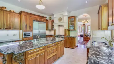 Stainless steel appliances, including a professional-grade Viking gas range provides modern convenience, while the elegant hood and custom millwork evoke timeless craftsmanship. This gourmet kitchen also features a Viking refrigerator, 2nd oven and more.