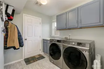 Main floor laundry room w/ utility sink and cabinet space